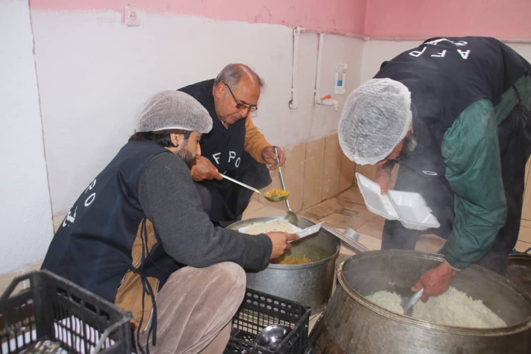 An image of volunteers from AFPO preparing meals to those in need.